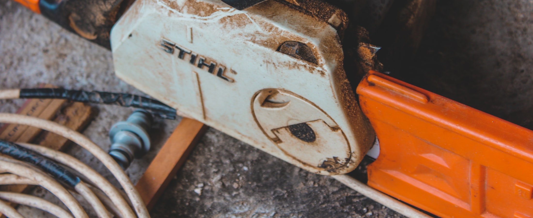 A STIHL chainsaw resting on the ground after cutting