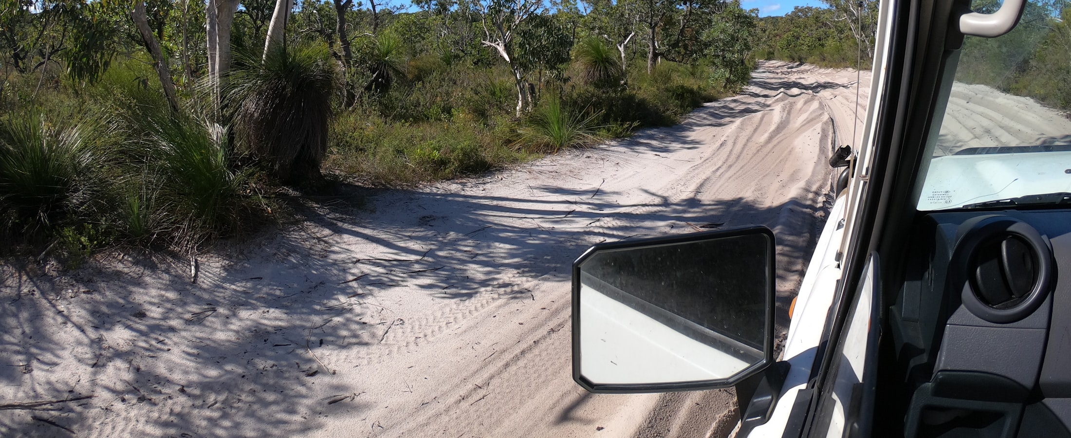 A vehicle on a country road lined with gum trees in western Victoria